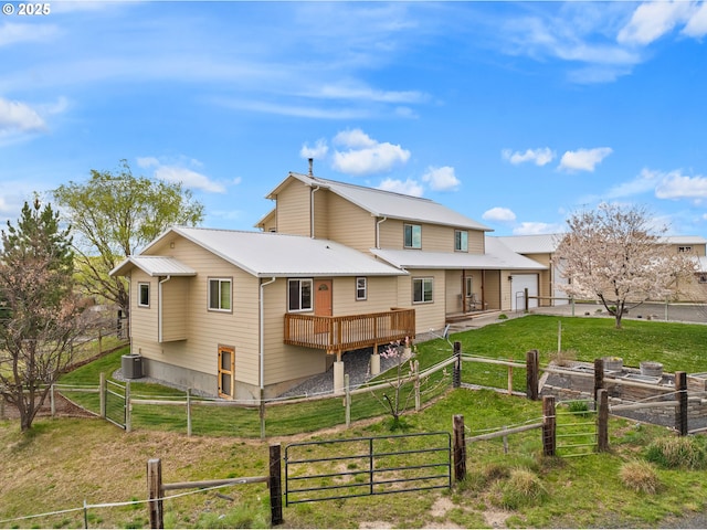 back of house featuring a yard, fence private yard, metal roof, a gate, and central AC unit