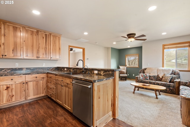 kitchen with open floor plan, dishwasher, a sink, and a peninsula
