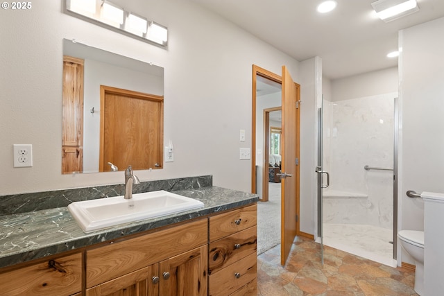 bathroom with toilet, a shower stall, vanity, and recessed lighting