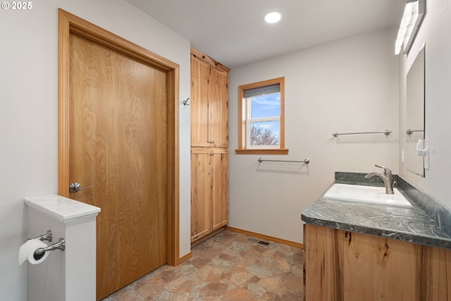 bathroom featuring stone finish floor, vanity, visible vents, recessed lighting, and baseboards