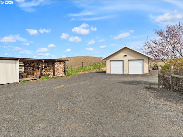 detached garage featuring fence