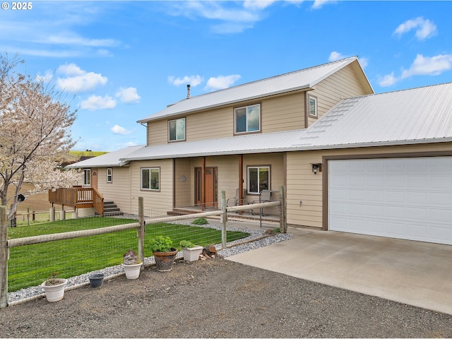 traditional-style home with driveway, a front lawn, and metal roof