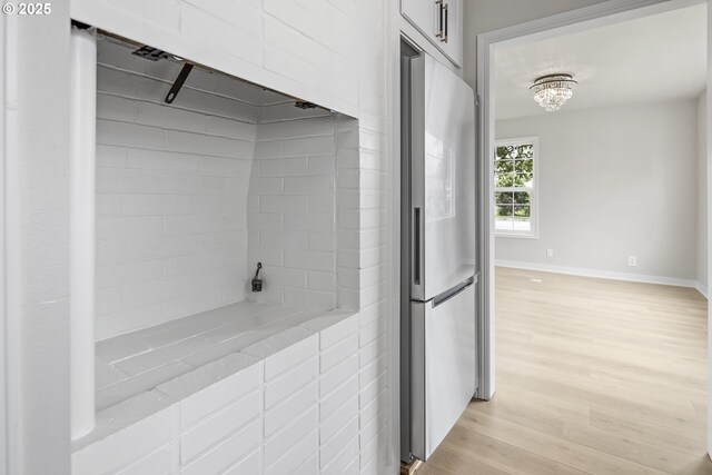 1061 NE Avery St, Newport, OR 97365 - kitchen featuring freestanding refrigerator, light countertops, light wood finished floors, baseboards, and a chandelier