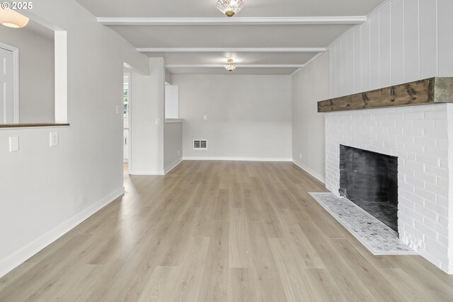 1061 NE Avery St, Newport, OR 97365 - unfurnished living room featuring beamed ceiling, light wood-type flooring, a fireplace, and baseboards