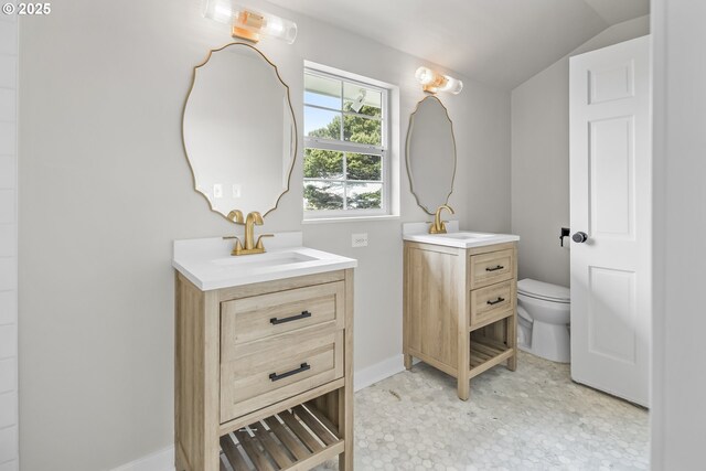 1061 NE Avery St, Newport, OR 97365 - bathroom featuring two vanities, toilet, lofted ceiling, and tile patterned floors