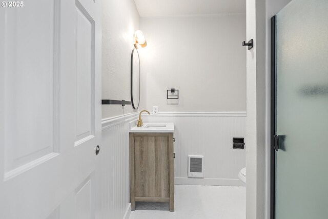 1061 NE Avery St, Newport, OR 97365 - bathroom featuring toilet, vanity, wainscoting, and a shower with door