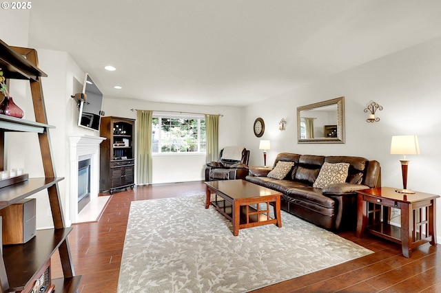 living area featuring a fireplace with flush hearth, wood finished floors, and recessed lighting