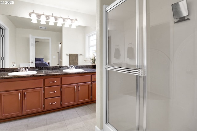 bathroom featuring tile patterned flooring, a sink, and a stall shower