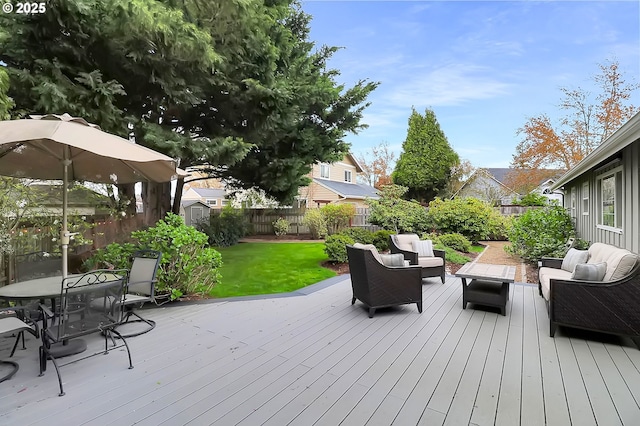 wooden terrace with a yard, outdoor dining space, a fenced backyard, and an outdoor living space