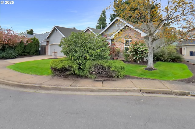 view of property hidden behind natural elements featuring a front lawn, driveway, and a garage