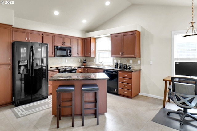 kitchen featuring black appliances, lofted ceiling, tasteful backsplash, and a sink