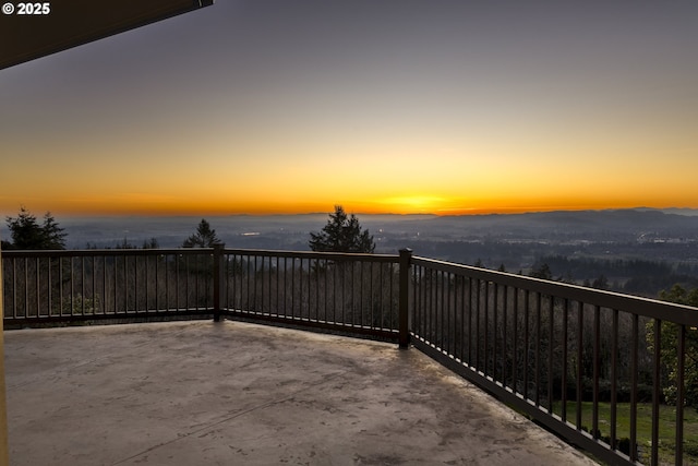 patio terrace at dusk featuring a balcony