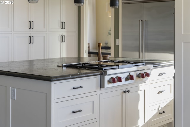 kitchen featuring stainless steel appliances, white cabinets, and decorative light fixtures