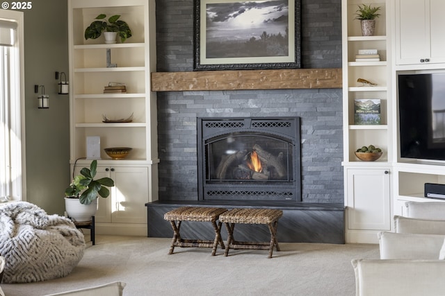 interior space featuring built in shelves, a large fireplace, and carpet flooring