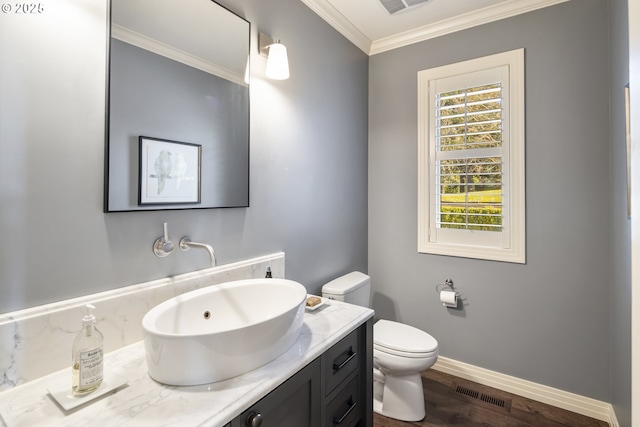 bathroom with vanity, hardwood / wood-style floors, crown molding, and toilet