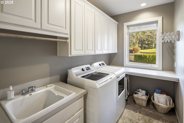 laundry area featuring independent washer and dryer, cabinets, and sink