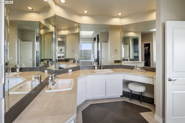 bathroom featuring vanity, a skylight, and tile patterned flooring