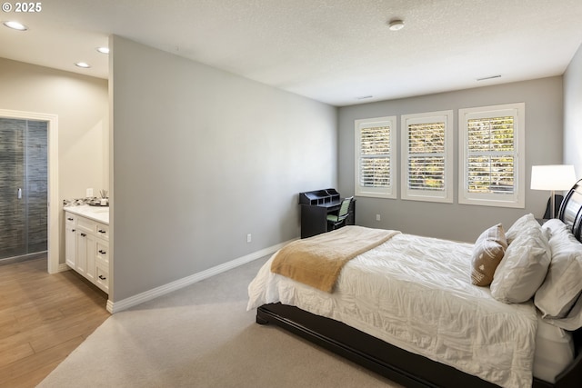 bedroom with a textured ceiling and light wood-type flooring