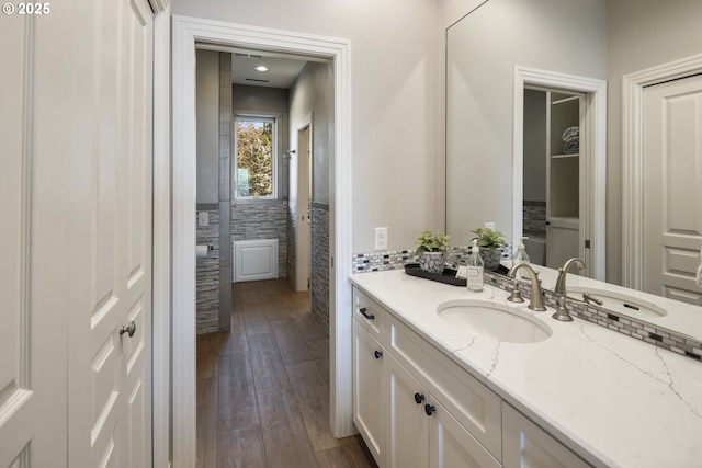 bathroom with vanity, hardwood / wood-style floors, and tile walls