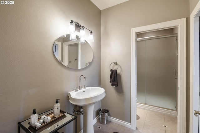 bathroom with tile patterned flooring, sink, and a shower with door