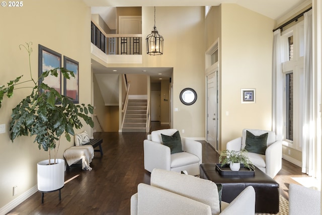 living room with a towering ceiling and dark hardwood / wood-style flooring