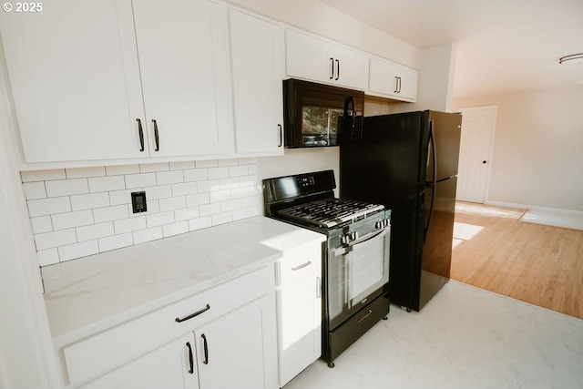 kitchen featuring decorative backsplash, black appliances, light stone counters, baseboards, and white cabinets