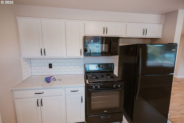 2797 Tulip St, Eugene, OR 97408 - kitchen featuring black appliances, white cabinetry, light stone counters, and tasteful backsplash