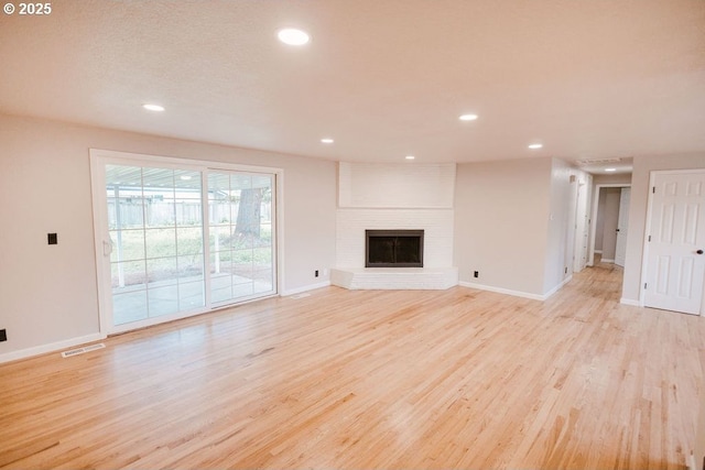 2797 Tulip St, Eugene, OR 97408 - unfurnished living room featuring light wood-style floors, baseboards, recessed lighting, and a brick fireplace
