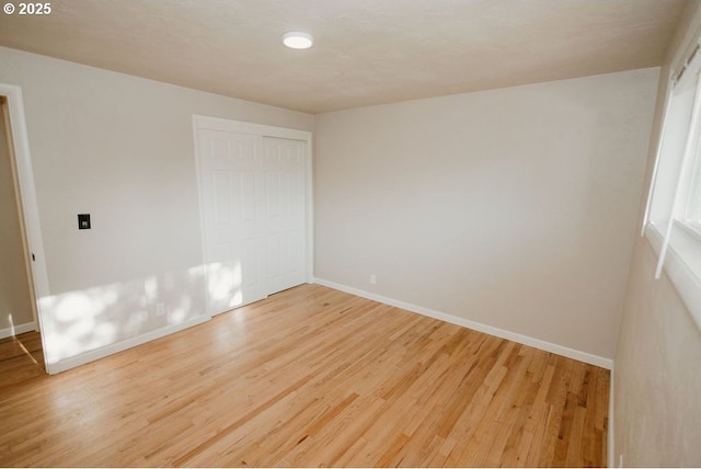 spare room featuring baseboards and wood finished floors