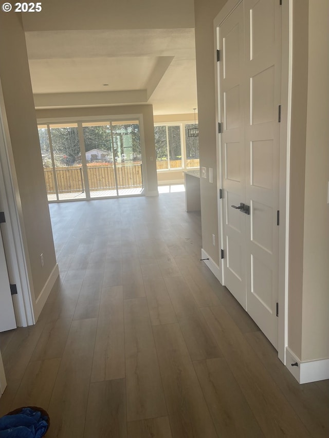 hallway featuring baseboards and wood finished floors