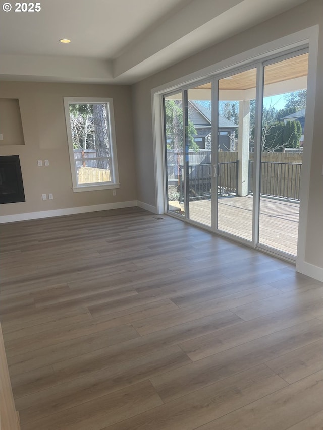 unfurnished living room featuring recessed lighting, baseboards, and wood finished floors