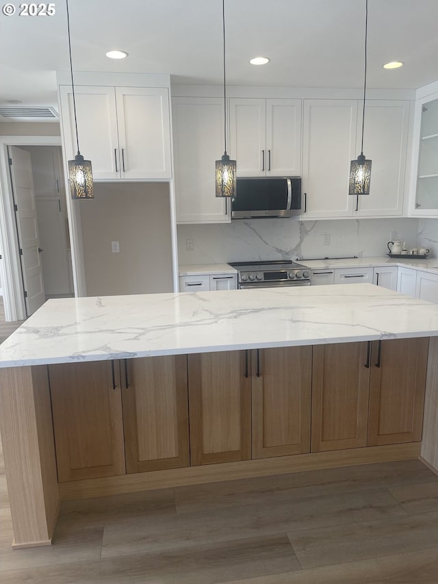 kitchen featuring white cabinetry, appliances with stainless steel finishes, and decorative backsplash