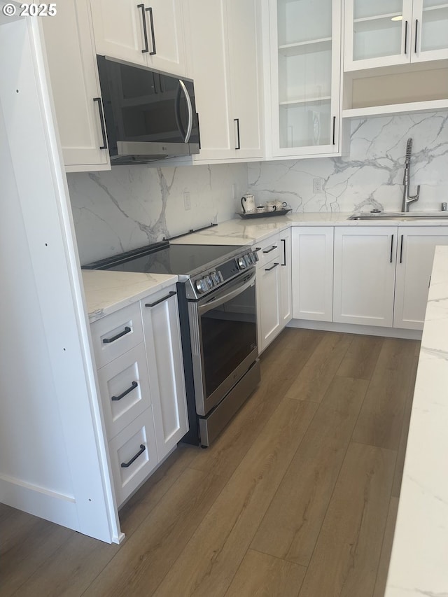 kitchen featuring appliances with stainless steel finishes, white cabinets, and a sink