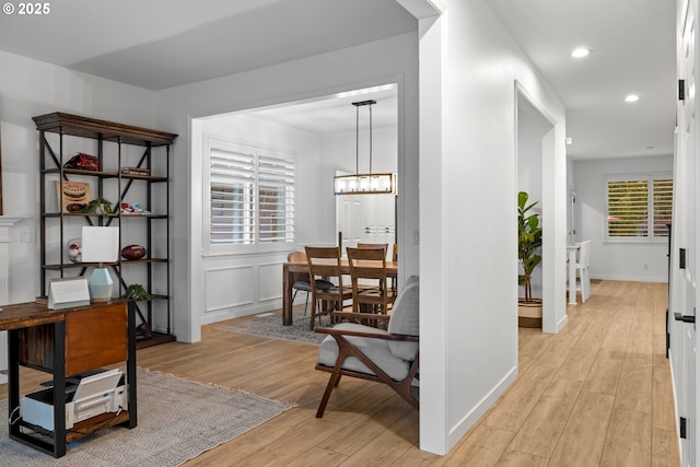 hallway featuring recessed lighting, light wood-type flooring, baseboards, and a chandelier