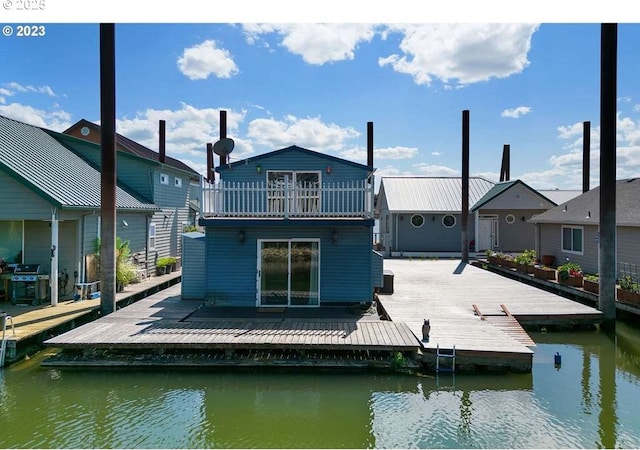 rear view of house featuring a balcony and a water view