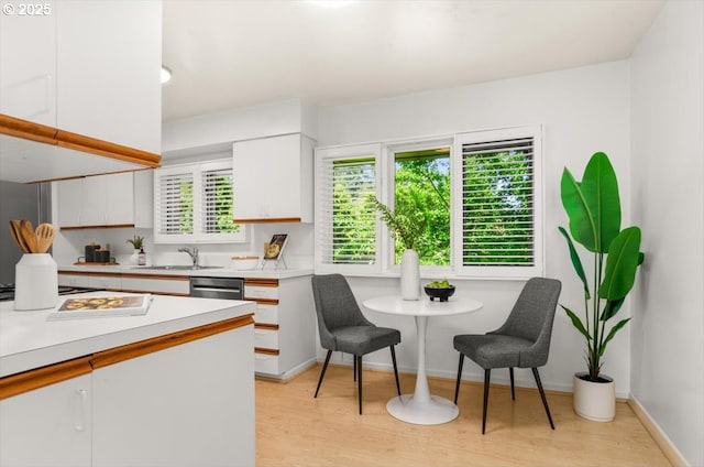2425 SW 19th Ave Unit 9, Portland, OR 97201 - kitchen featuring white cabinets, light countertops, light wood-type flooring, stainless steel dishwasher, and cooktop