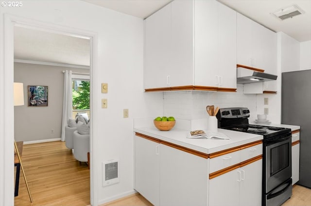 2425 SW 19th Ave Unit 9, Portland, OR 97201 - kitchen with stainless steel electric range, under cabinet range hood, light countertops, light wood-type flooring, and tasteful backsplash