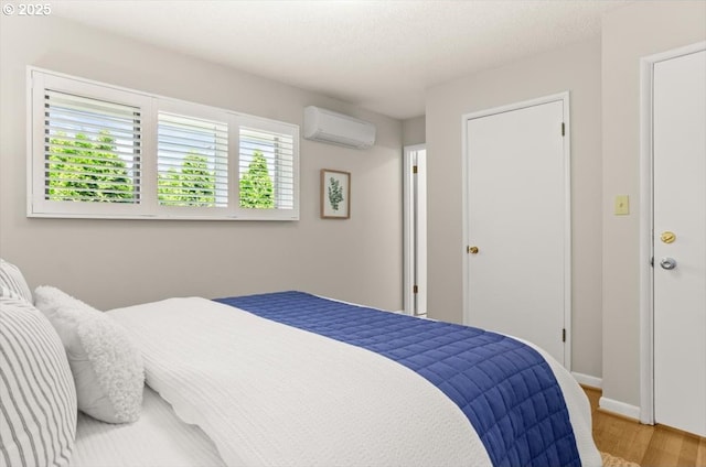 2425 SW 19th Ave Unit 9, Portland, OR 97201 - bedroom with a wall unit AC and wood finished floors