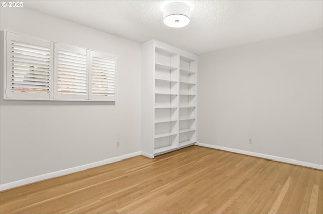 2425 SW 19th Ave Unit 9, Portland, OR 97201 - unfurnished room with light wood-type flooring, a textured ceiling, and built in features