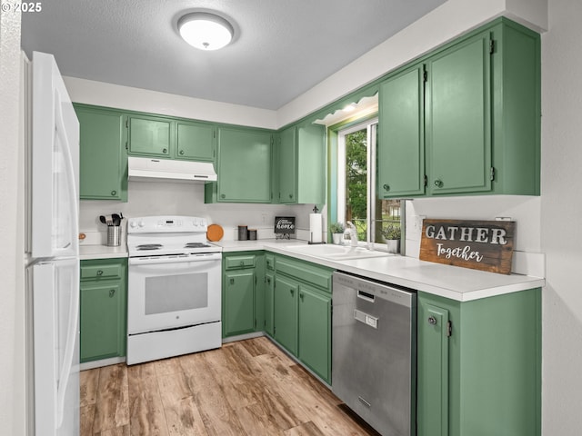 kitchen with white appliances, sink, green cabinets, and light wood-type flooring