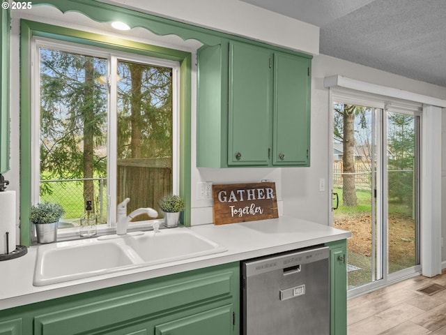 bar with green cabinets, dishwasher, sink, and a textured ceiling