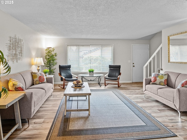 living room featuring light hardwood / wood-style flooring and a textured ceiling