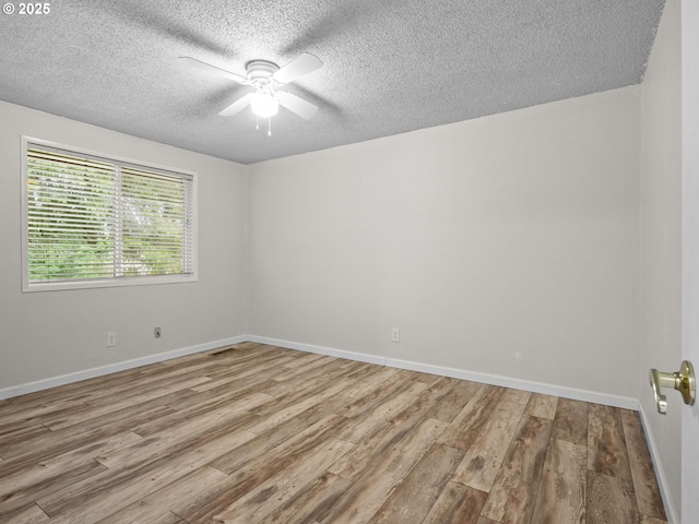 unfurnished room with ceiling fan, a textured ceiling, and light wood-type flooring