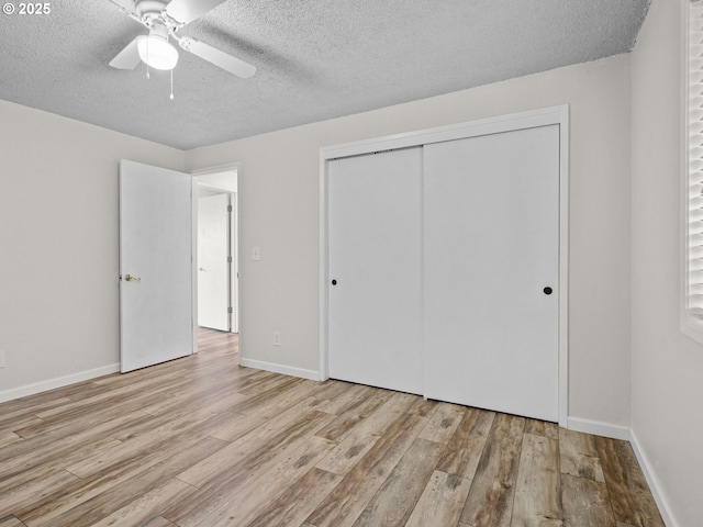 unfurnished bedroom with ceiling fan, a textured ceiling, light hardwood / wood-style floors, and a closet