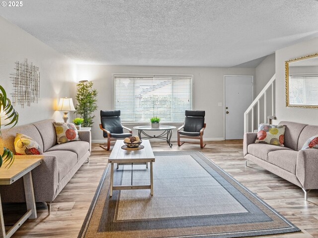 living room featuring a textured ceiling and light wood-type flooring