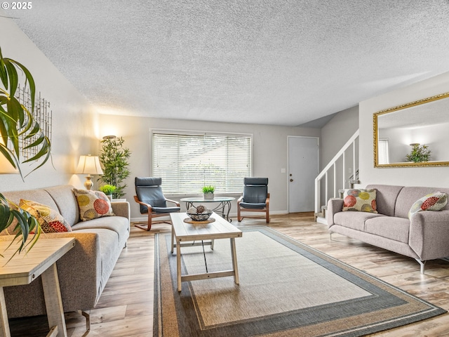 living room with light hardwood / wood-style floors and a textured ceiling