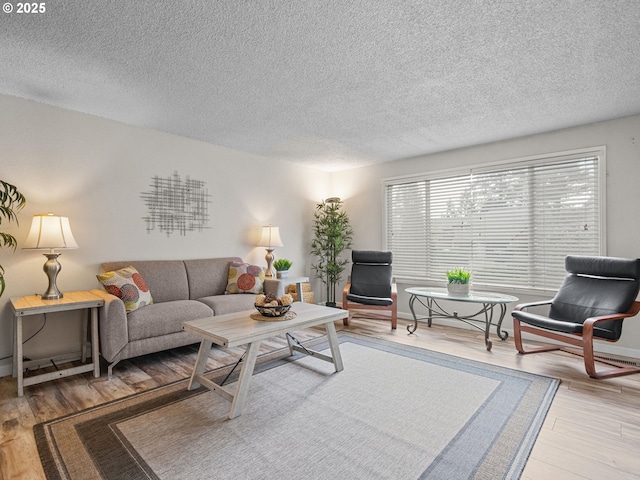 living room featuring light hardwood / wood-style flooring and a textured ceiling