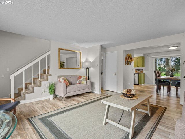 living room featuring wood-type flooring and a textured ceiling