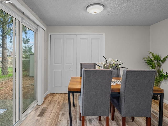 dining space featuring hardwood / wood-style flooring and a textured ceiling