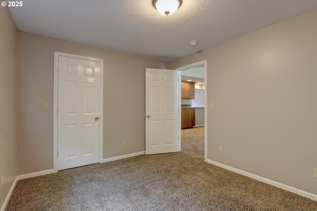 640 Sherman Dr, The Dalles, OR 97058 - unfurnished bedroom featuring light colored carpet, baseboards, and a textured ceiling